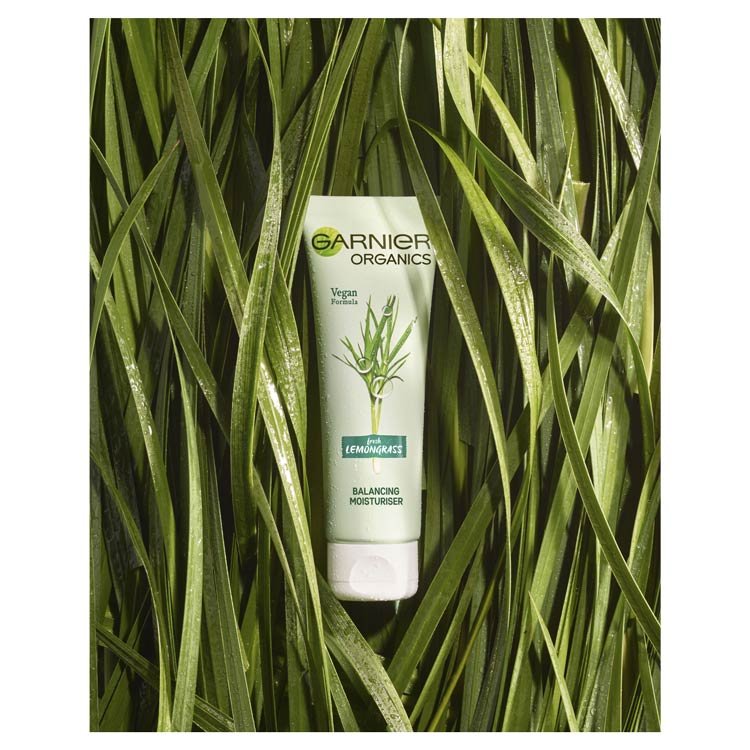 Garnier Organics Lemongrass Balancing Moisturiser product laying in lemongrass
